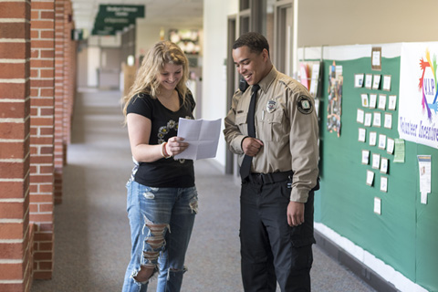 Clinton talking with student in his Public Safety uniform.