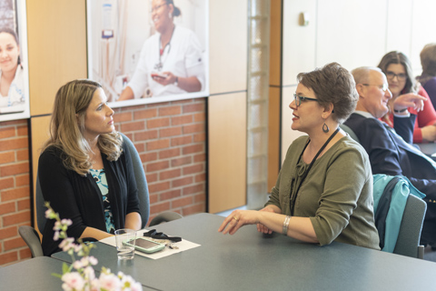 Kimberly speaking with a faculty member in a meeting