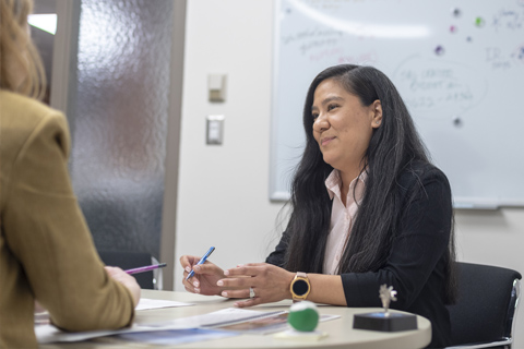 Monica speaking in a meeting.