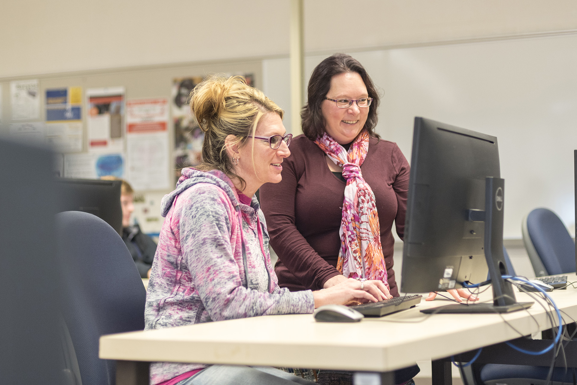 Sandi in a computer lab with her instructor.